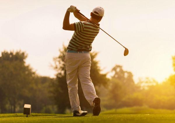 a man golfing pain free, thanks to his chiropractor.