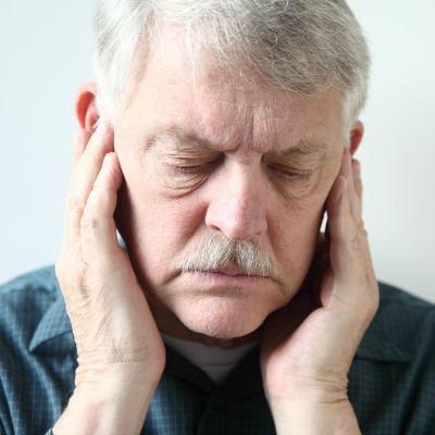 Older man with TMJ issuse thinking about going to his chiropractor.